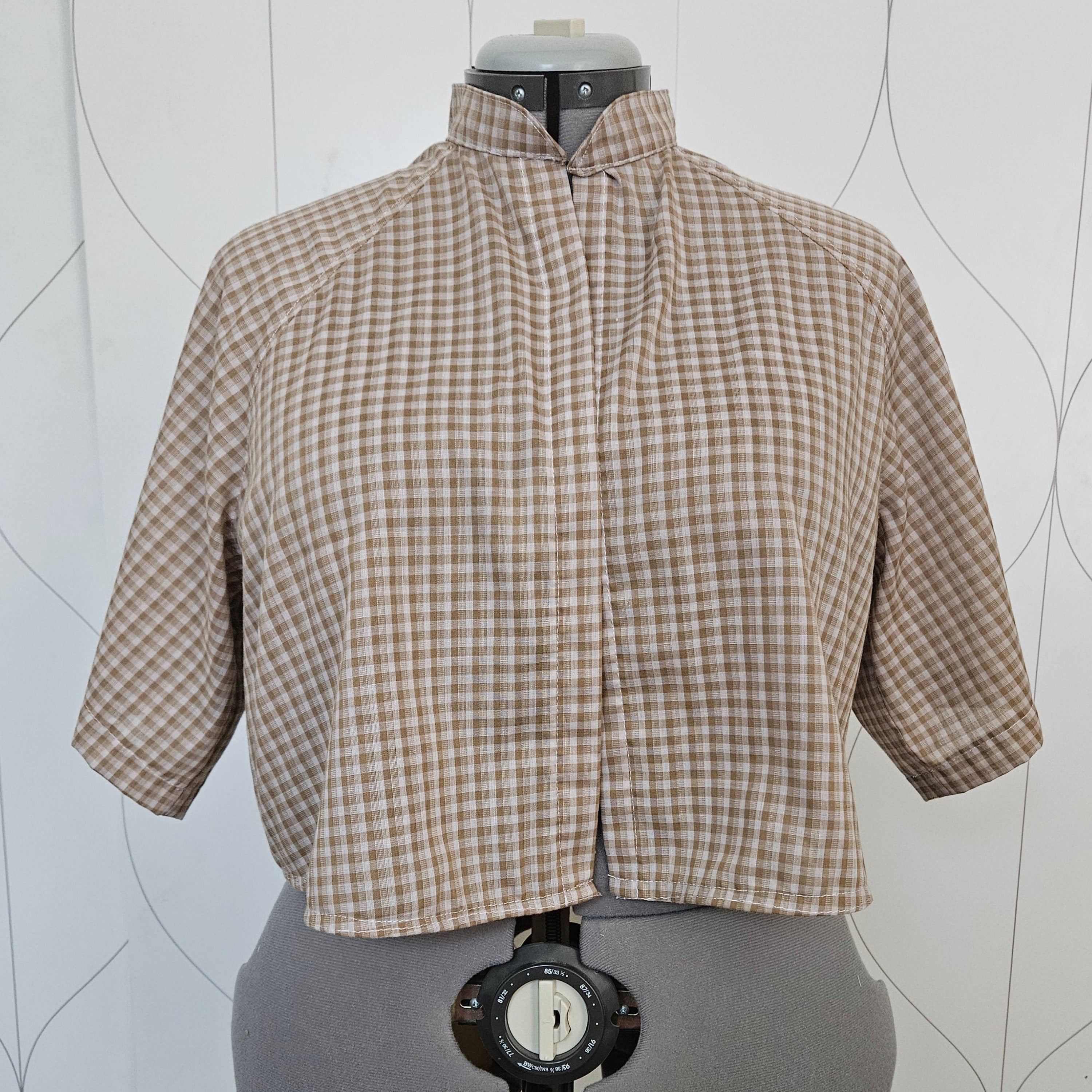 Front view of beige gingham button-up shirt