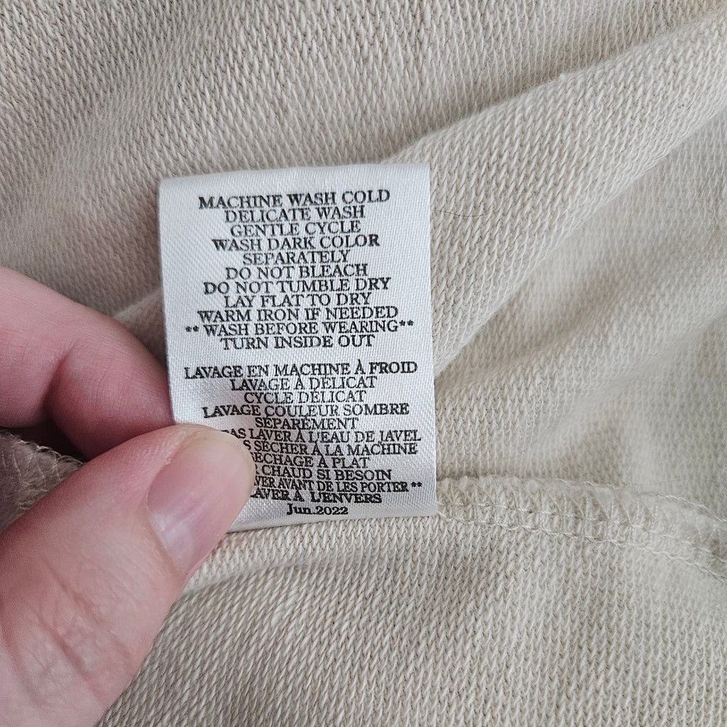 Care instructions tag on beige fabric background