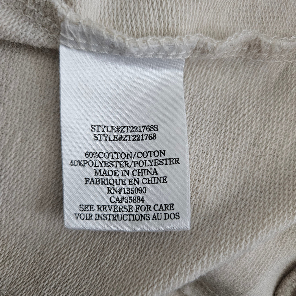 Clothing tag on beige fabric background