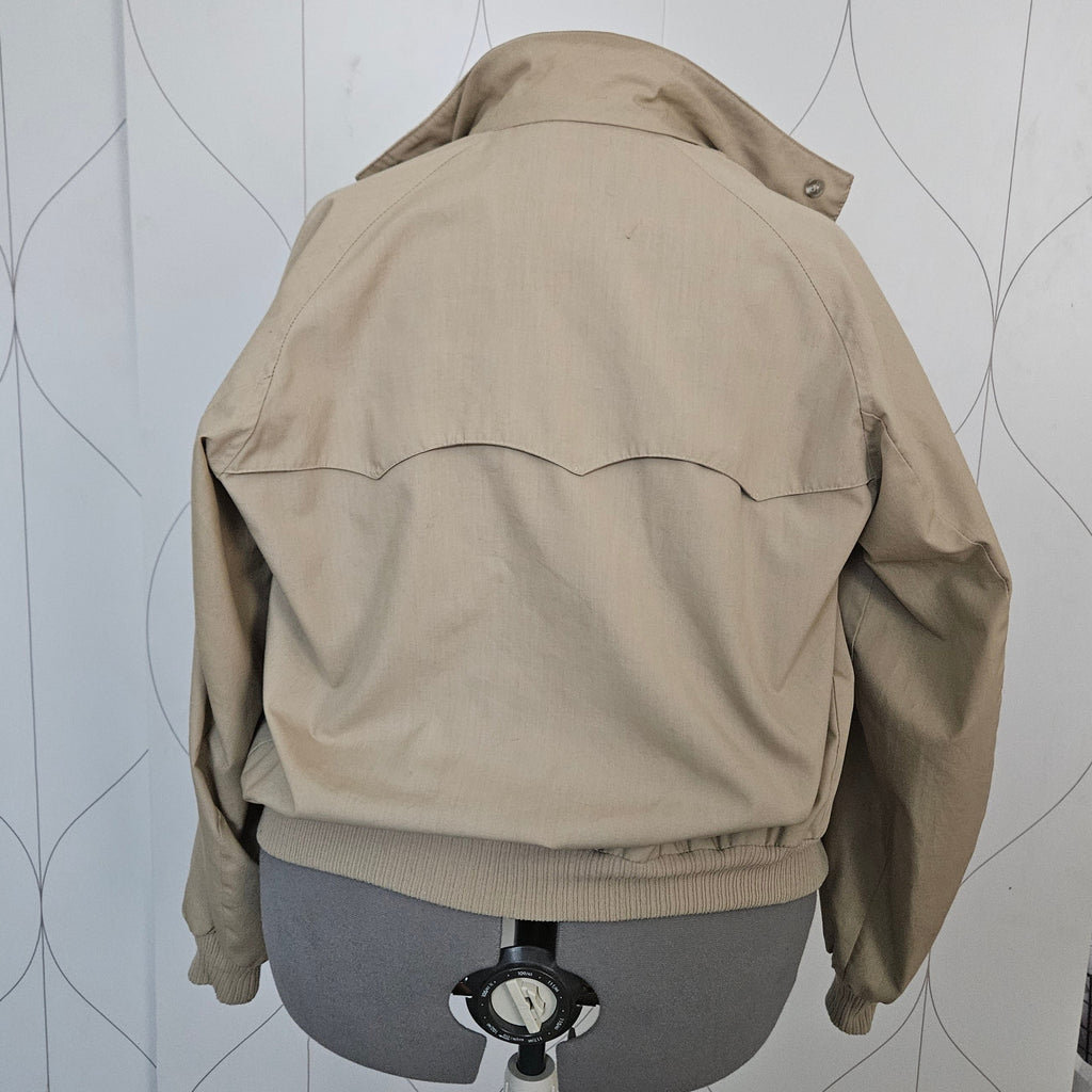 Back of beige jacket with ribbed bottom and curved back yoke