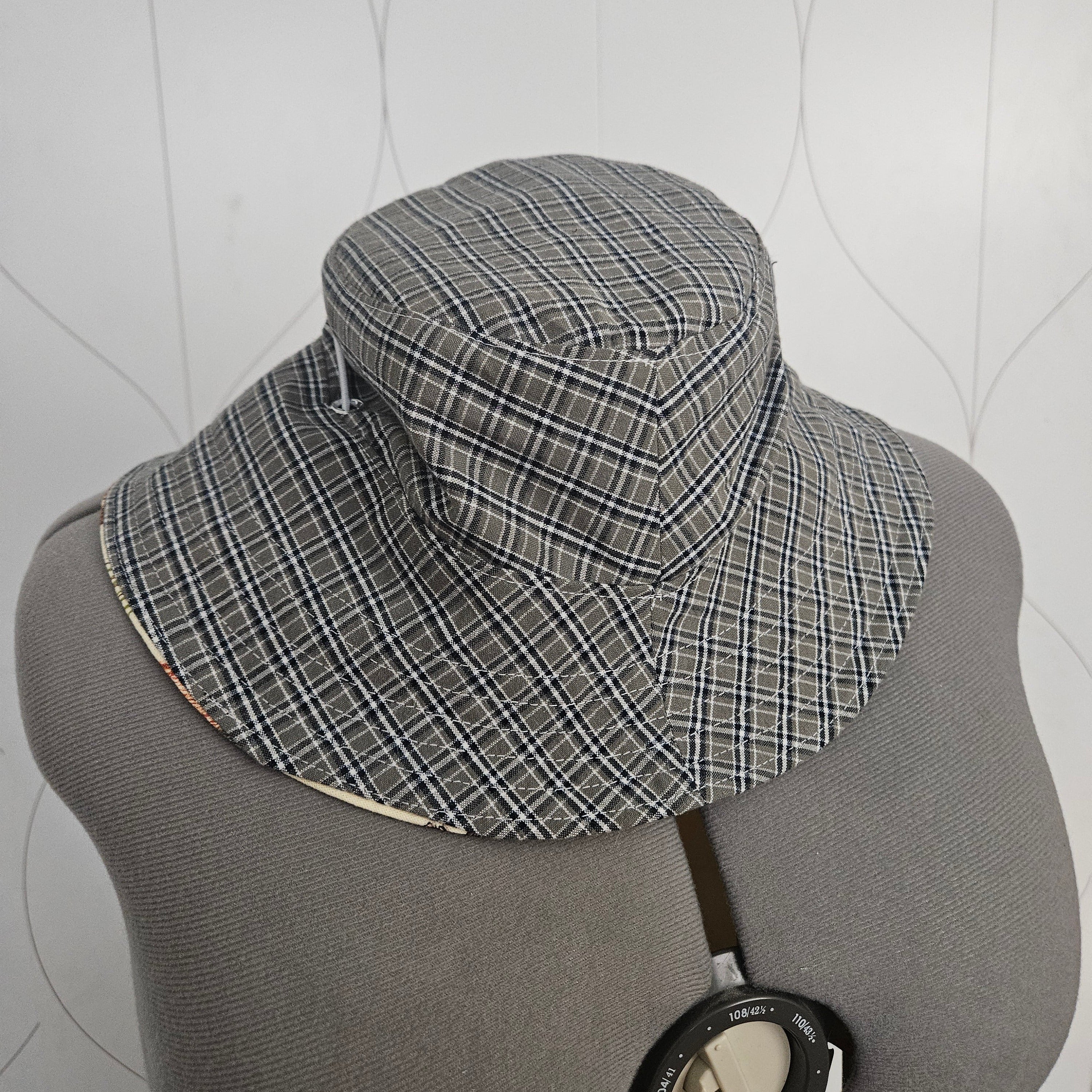 Green plaid bucket hat on a gray mannequin