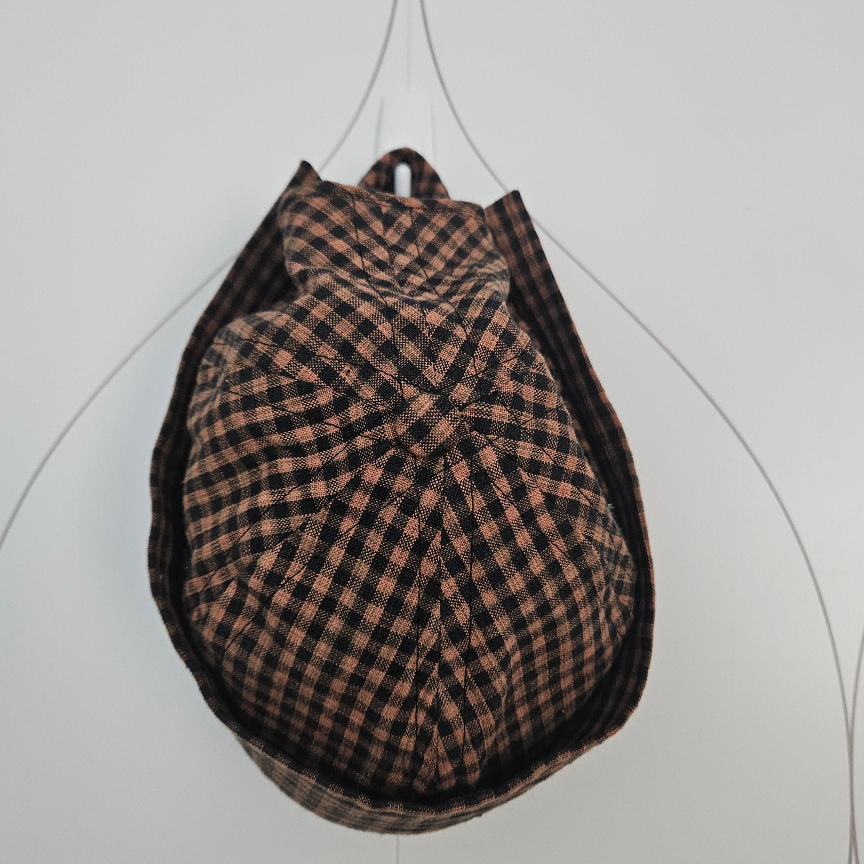 Top view of brown and black gingham brimless cap