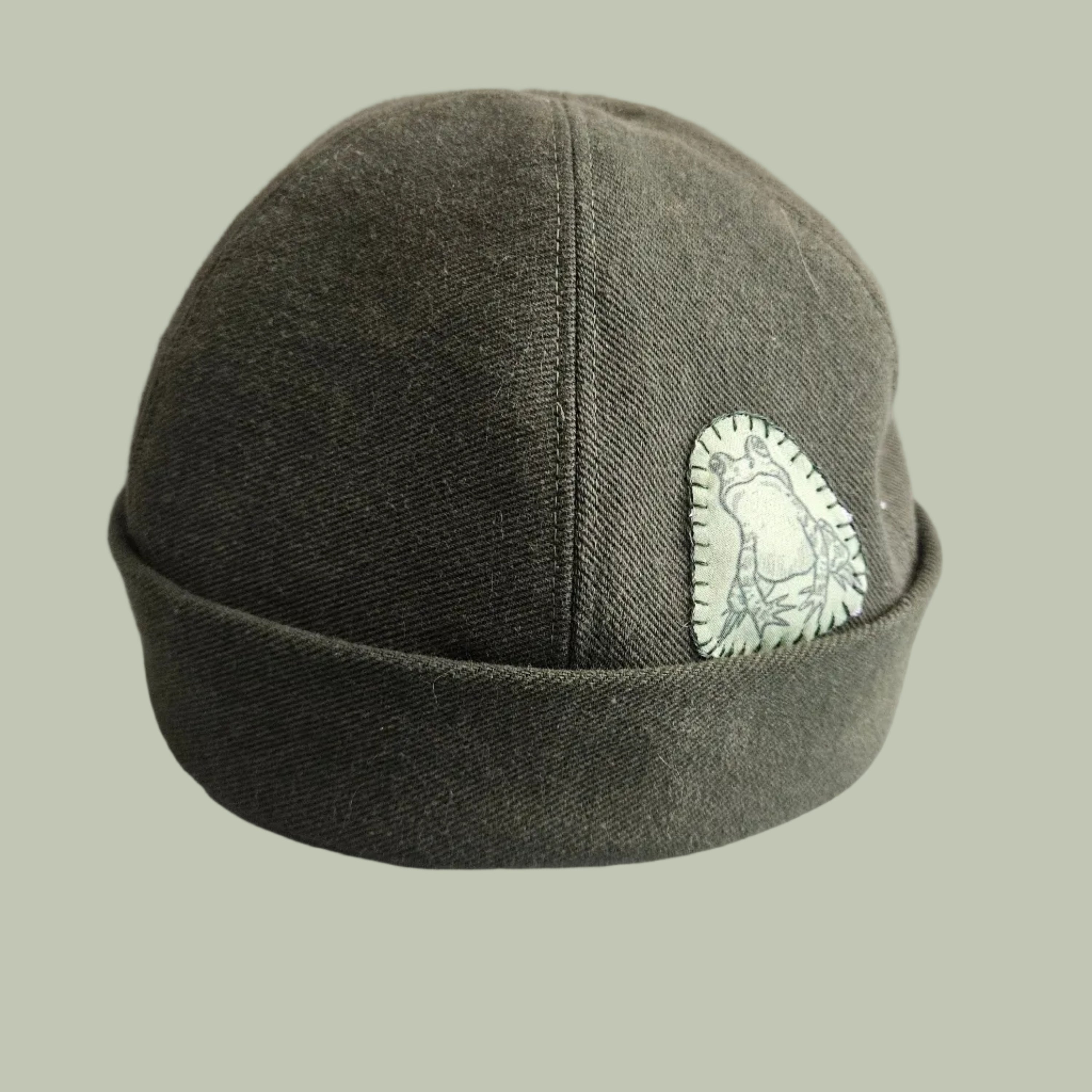 a green denim brimless hat with a frog print fabric embroidered on