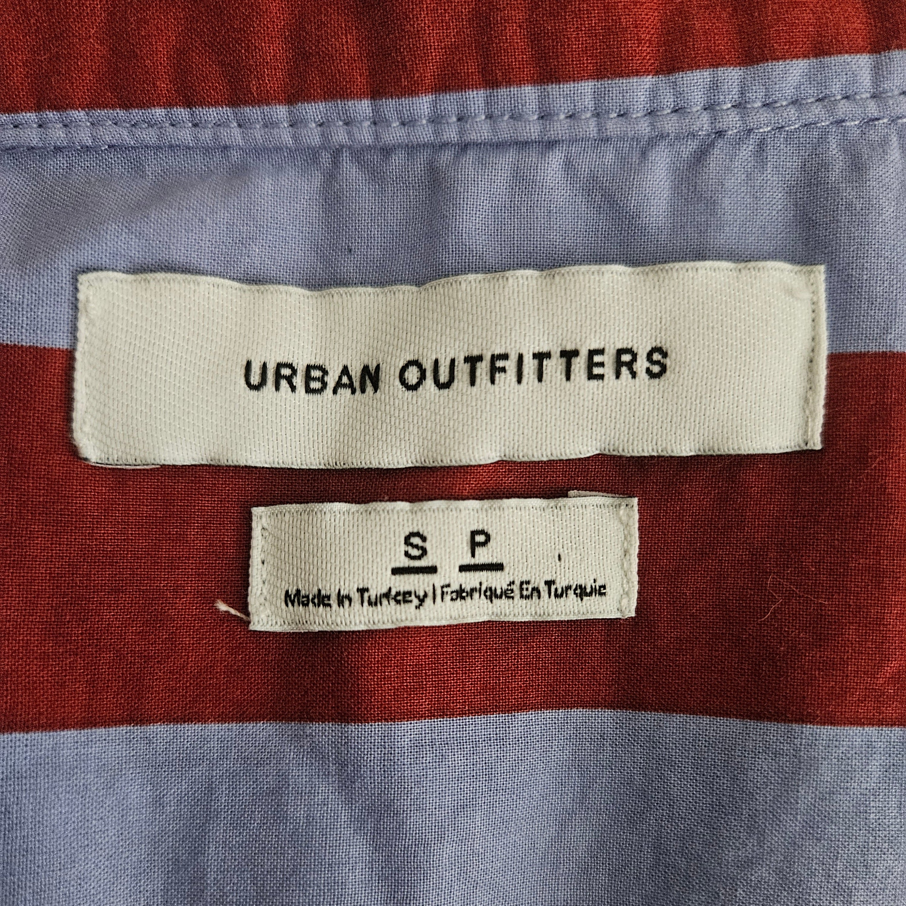 Brand clothing tag on purple and red striped background
