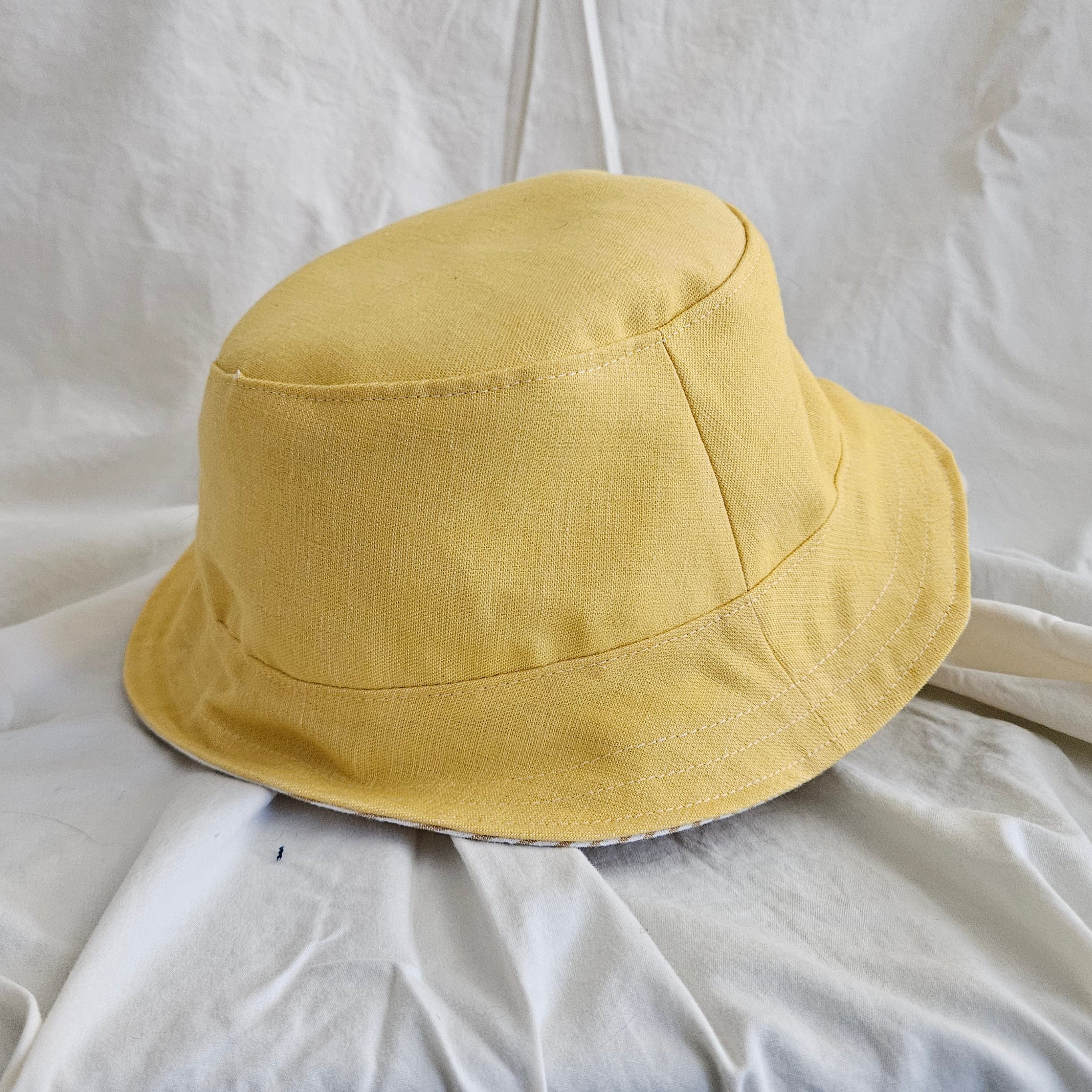 Yellow bucket hat on a white fabric background