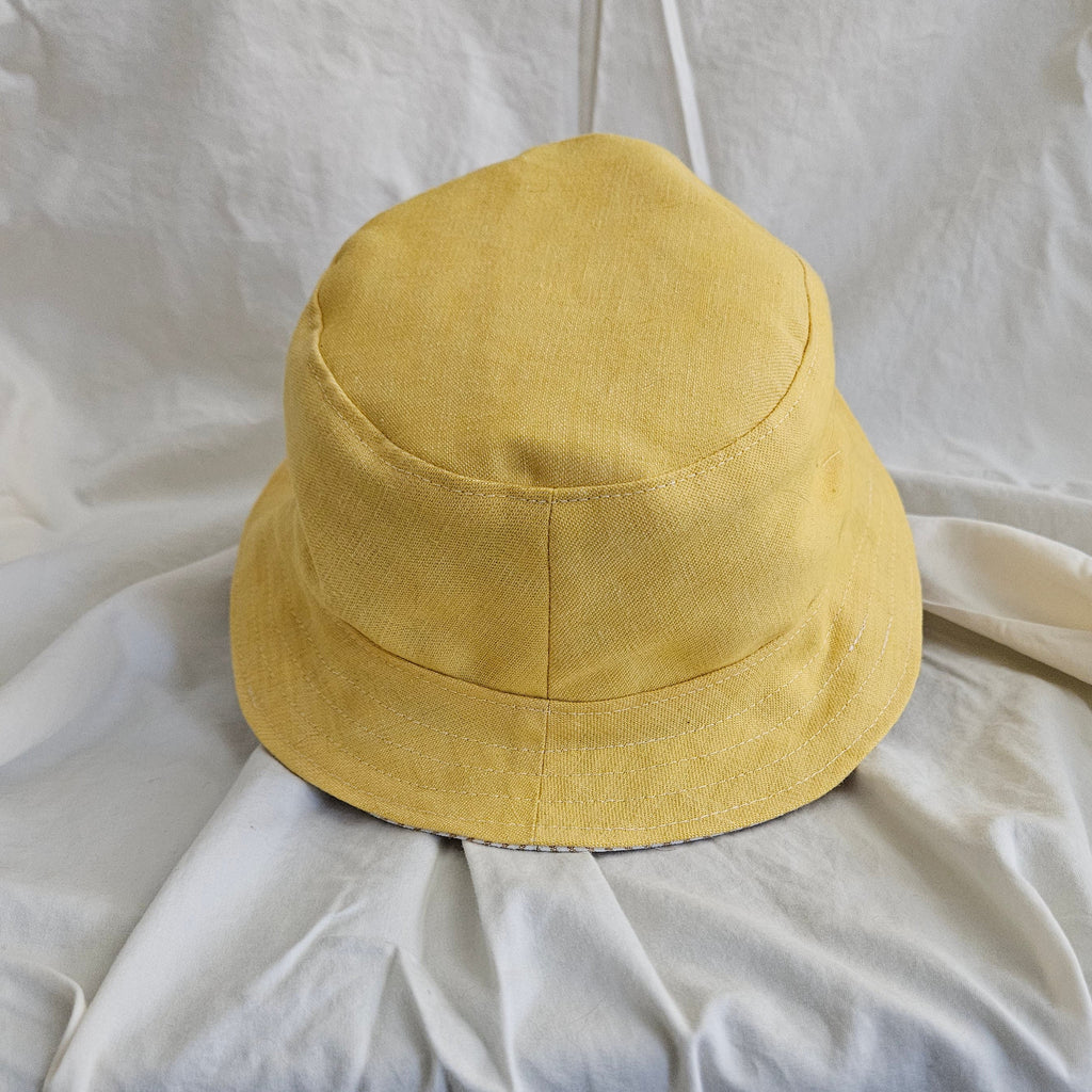 Yellow bucket hat on a white fabric background