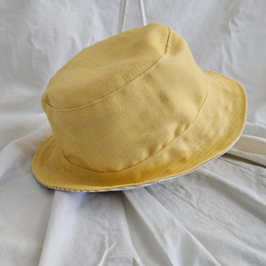 Yellow bucket hat on a white fabric background