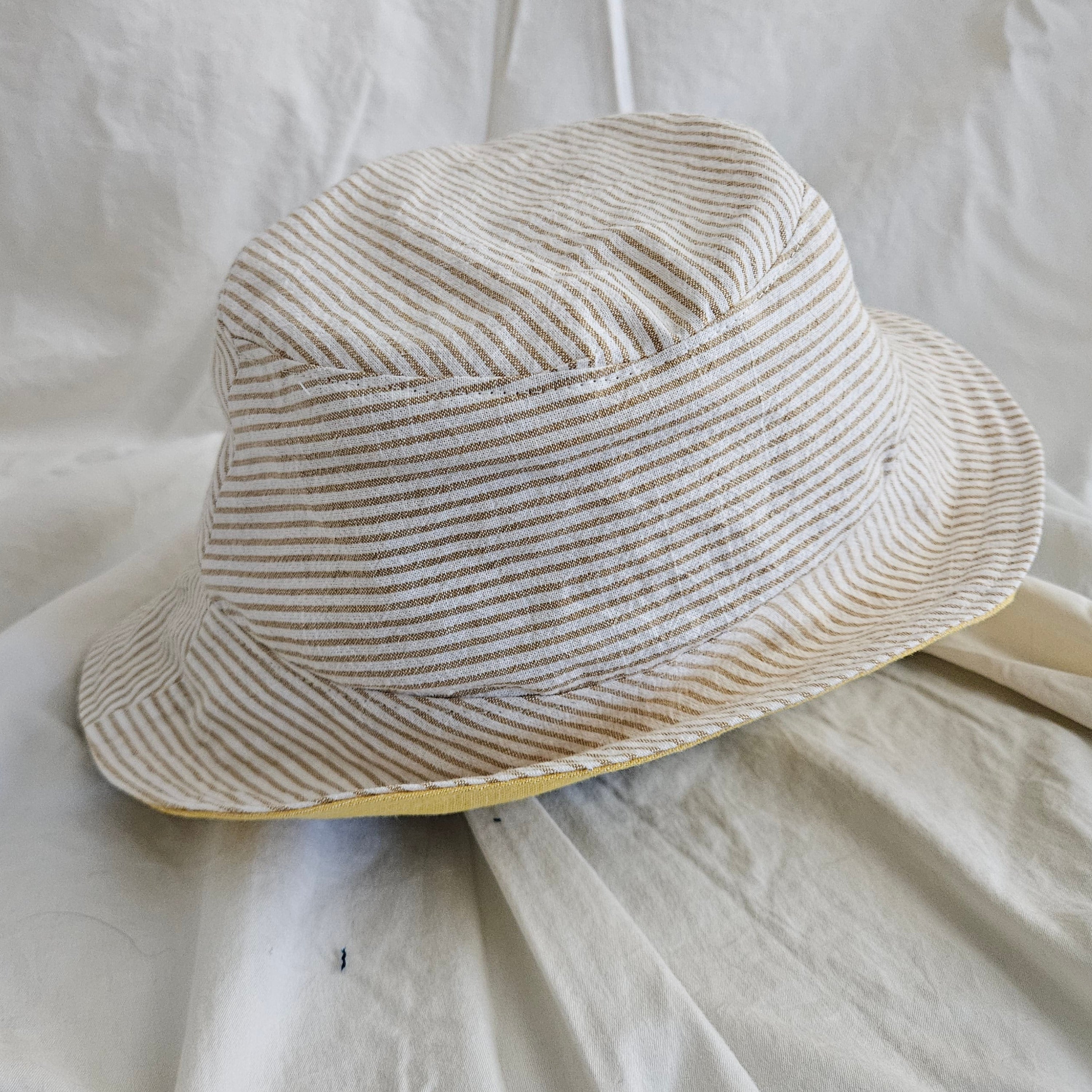 Striped bucket hat on a white fabric background